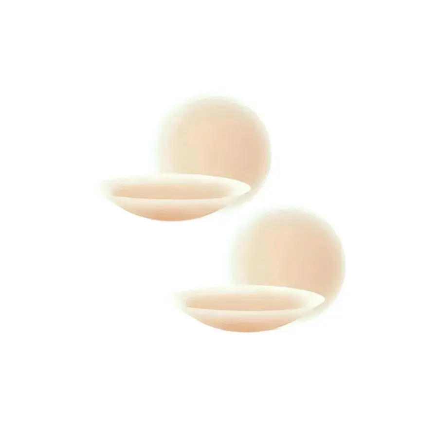 Twee huidkleurige siliconen nipple covers, ronde zelfklevende tepelbedekkers op een lichtroze achtergrond