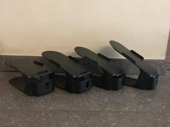 Vier zwarte schoenen opbergsystemen naast elkaar op een tegelvloer, elk in een andere hoogtestand versteld